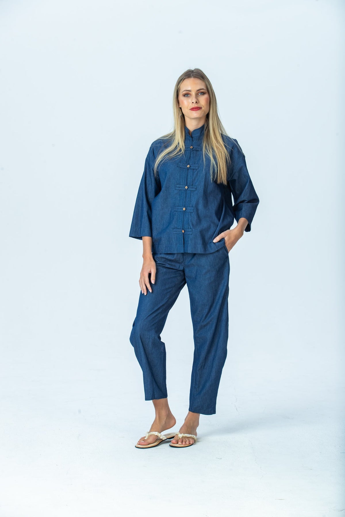 Parker denim barrel pants, front view full length with hand in pocket, one knee bent