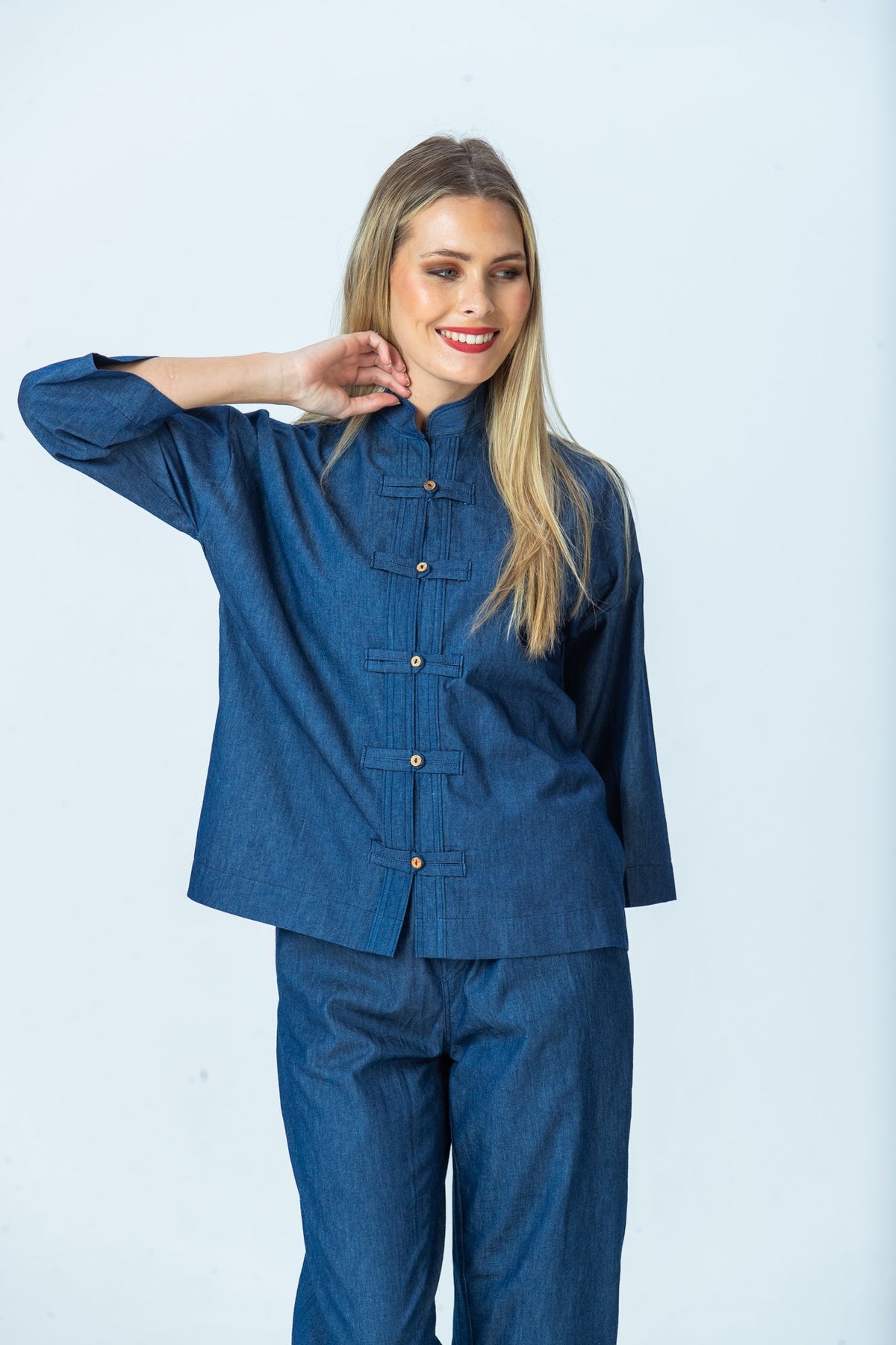 Kinsley denim kaftan-style shirt, front view with hand at neck, looking to the side