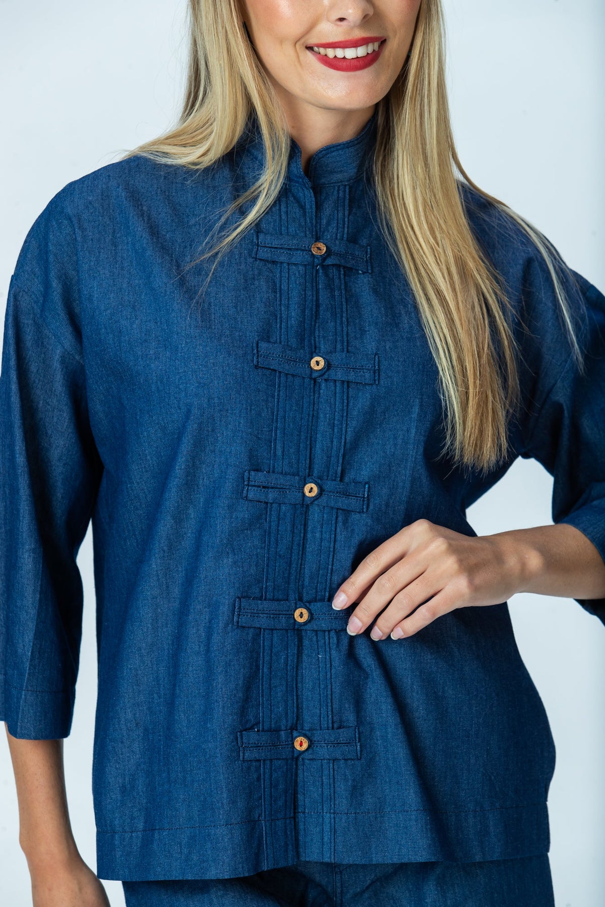 Kinsley denim kaftan shirt, close up of frog fastenings and red thread on the final fastening