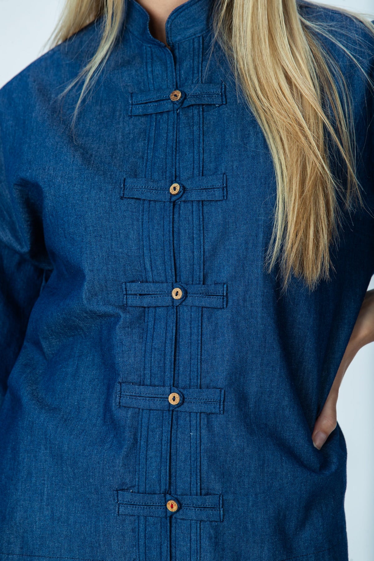 Kinsley denim kaftan-style shirt, close up of frog fastenings and pleat detailing