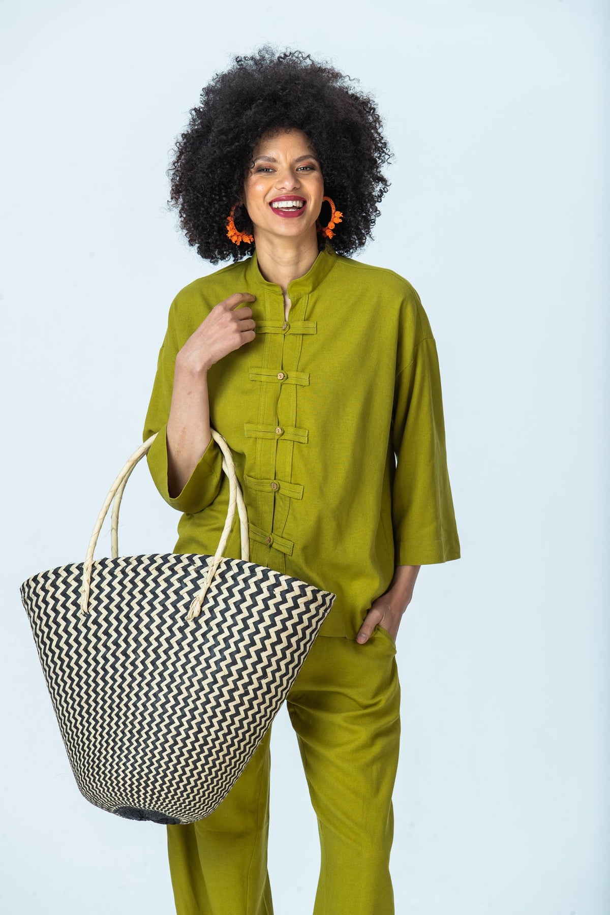 Kinsley chartreuse kaftan-style shirt, front view with hand at collar