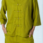 Kinsley chartreuse kaftan shirt, close up of frog fastenings and red thread on the final fastening