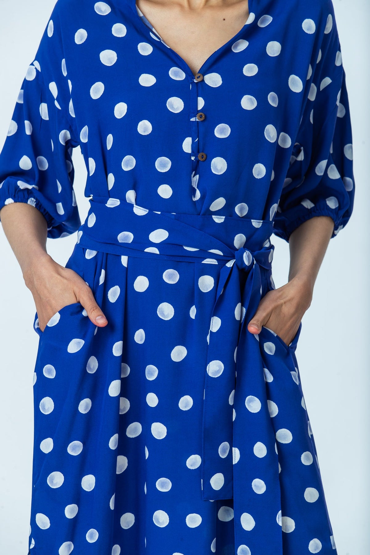 Sloane royal blue polka dot dress, close up of three-button placket, self-tie belt and pockets