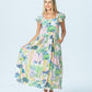 Sienna watercolour palm sundress, front view full length holding out the pleated skirt