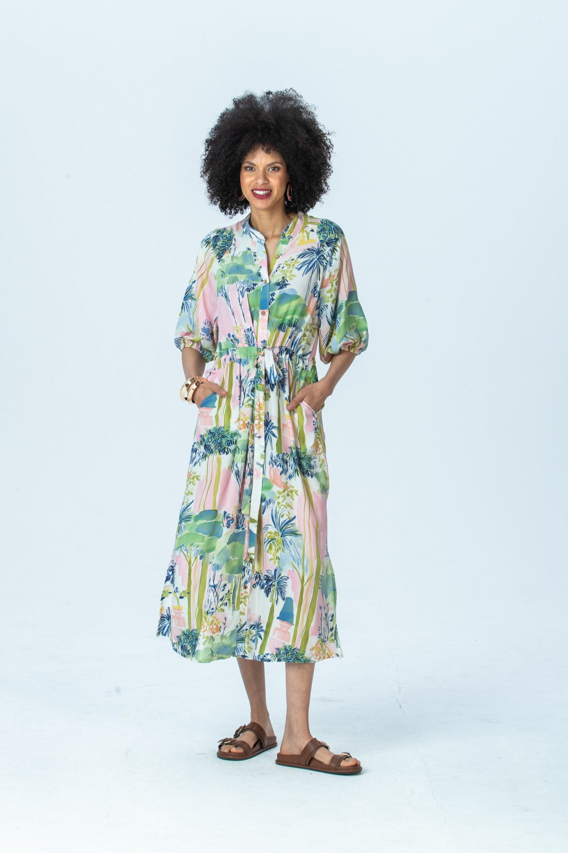 Shelby watercolour palm dress, front view full length, smiling, hands in pockets
