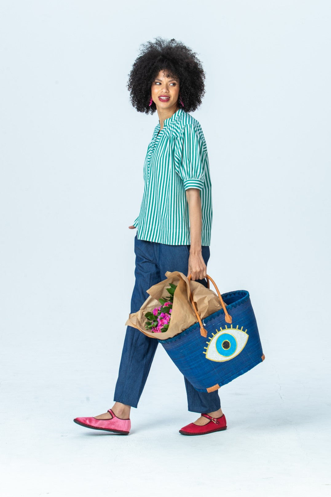 Tatum emerald stripe shirt, side view full length walking with a woven basket
