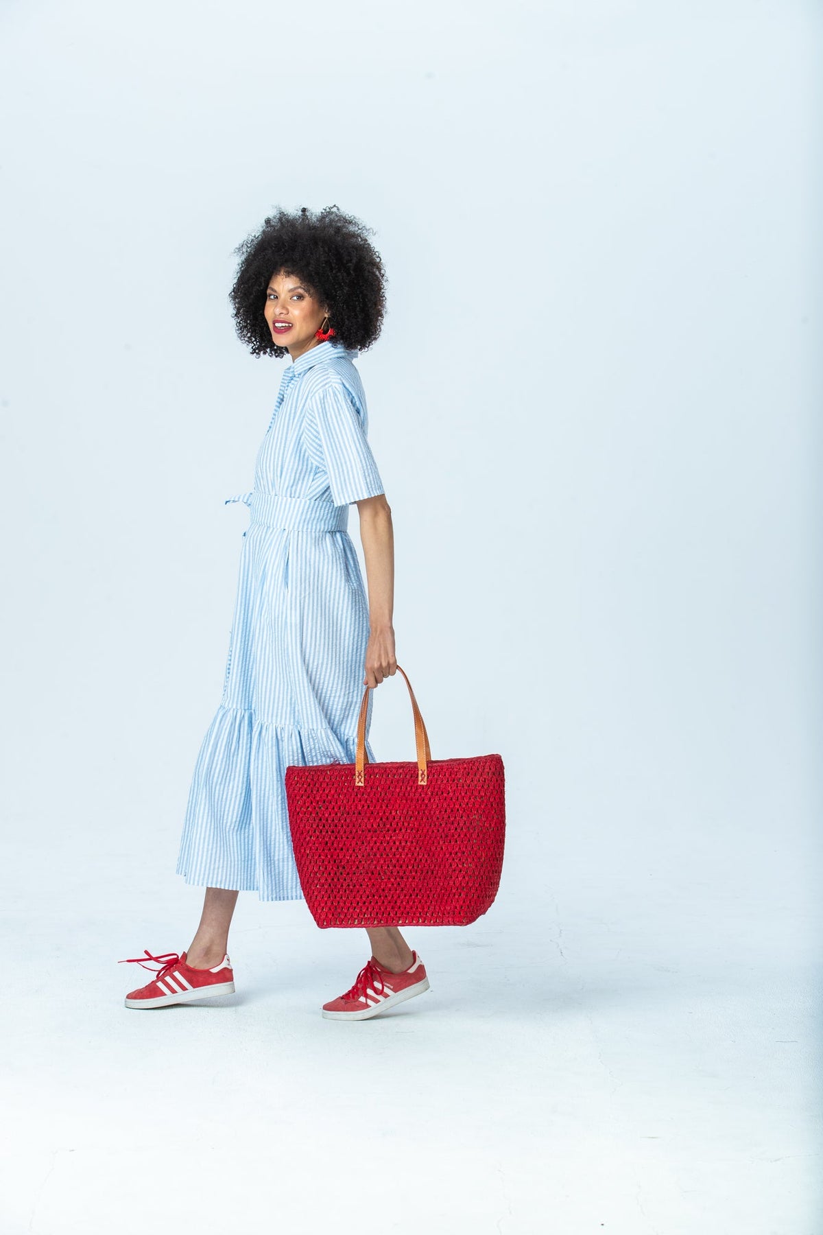 Frankie blue stripe shirt dress, side view full length walking with a red tote