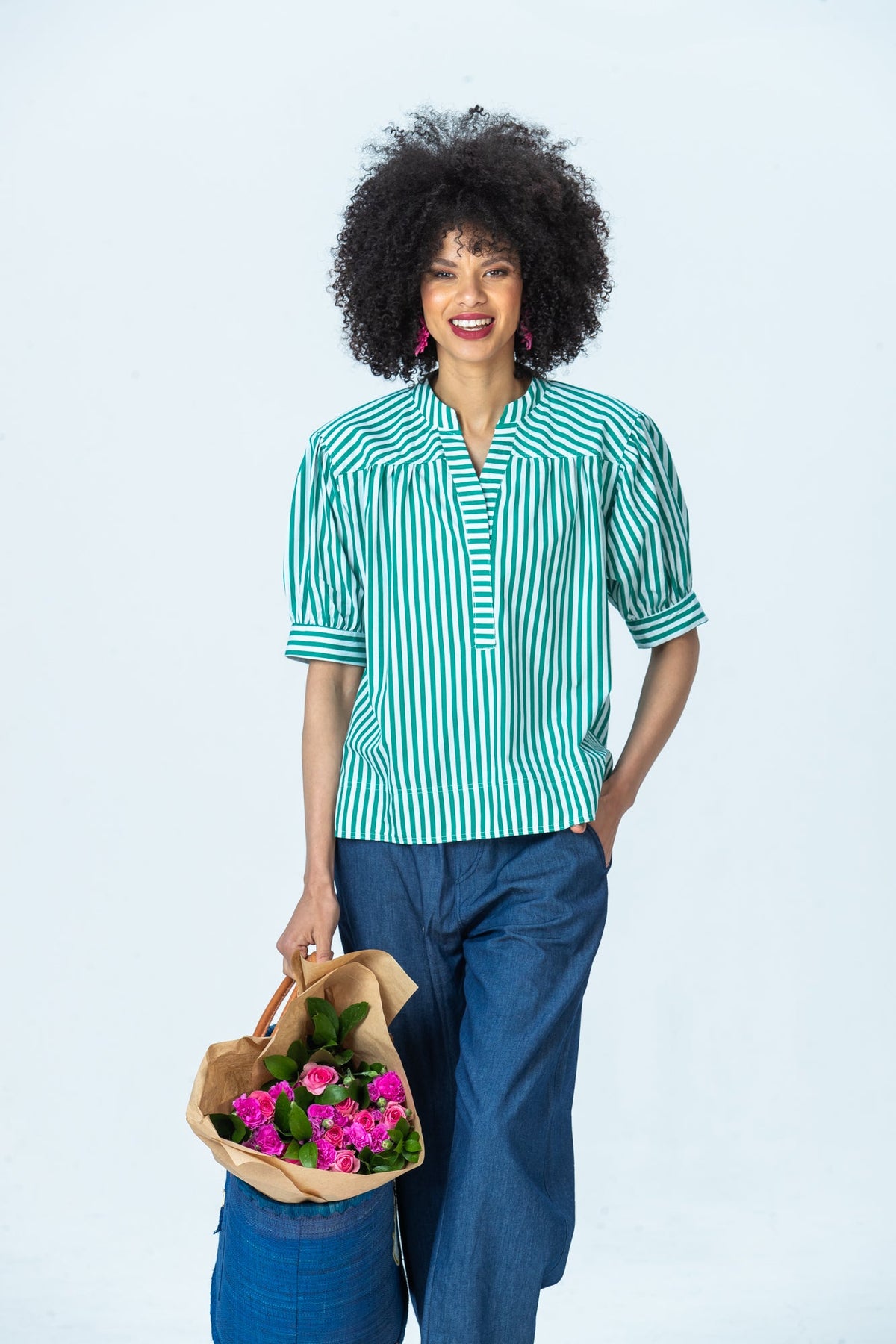 Tatum emerald stripe shirt, front view holding flowers, hand in pocket