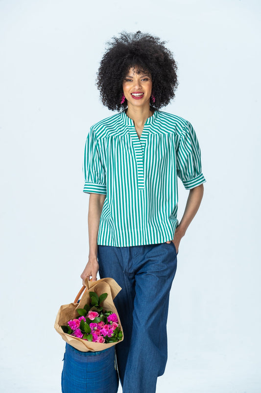 Tatum emerald stripe shirt, front view holding flowers, hand in pocket