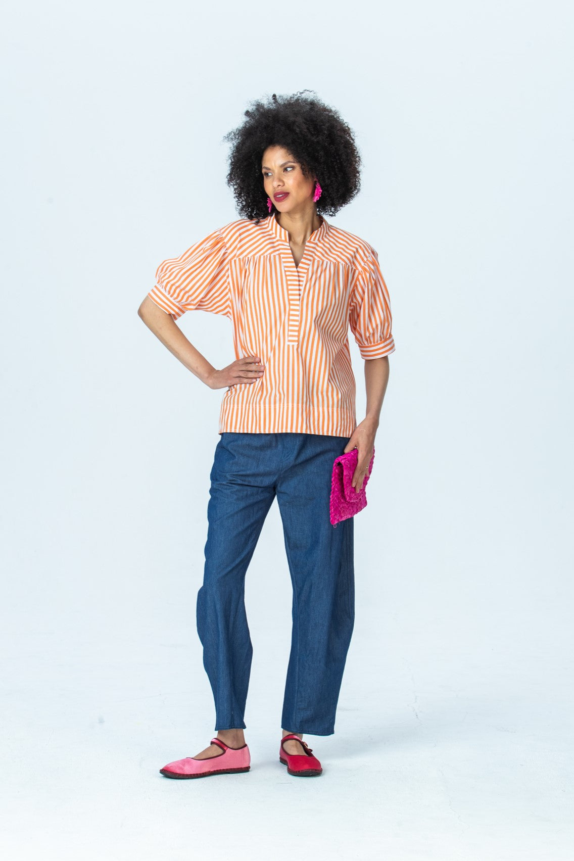 Tatum orange stripe shirt, front view full length with hand on hip