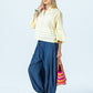 Serafina pale yellow shirt, side view full length with hand at collar