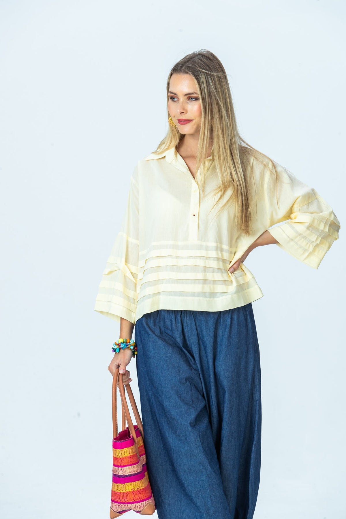 Serafina pale yellow shirt, three-quarter view with hand on hip