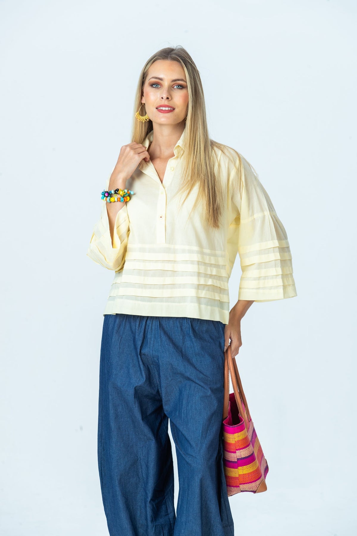 Serafina pale yellow shirt, front view with hand at collar