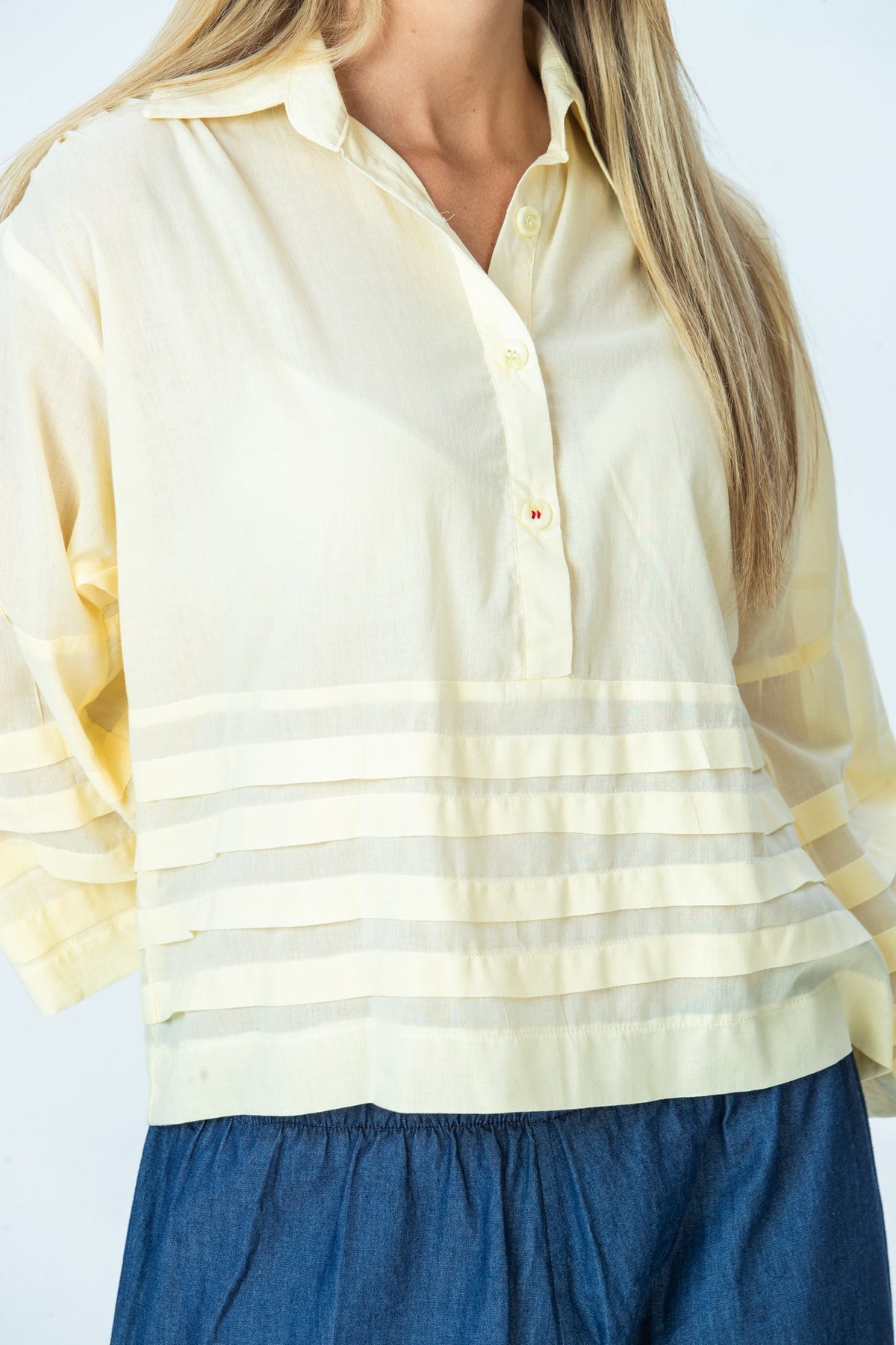 Serafina pale yellow shirt, close up of half-button placket and pintuck band