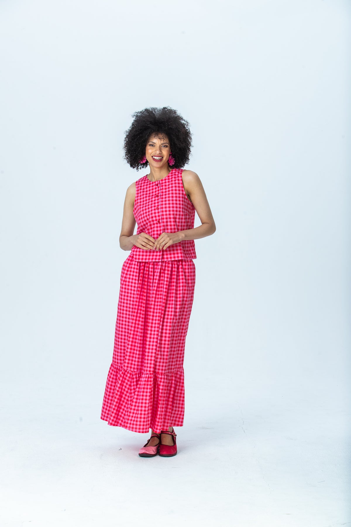 Riley red and pink check skirt, front view full length, smiling