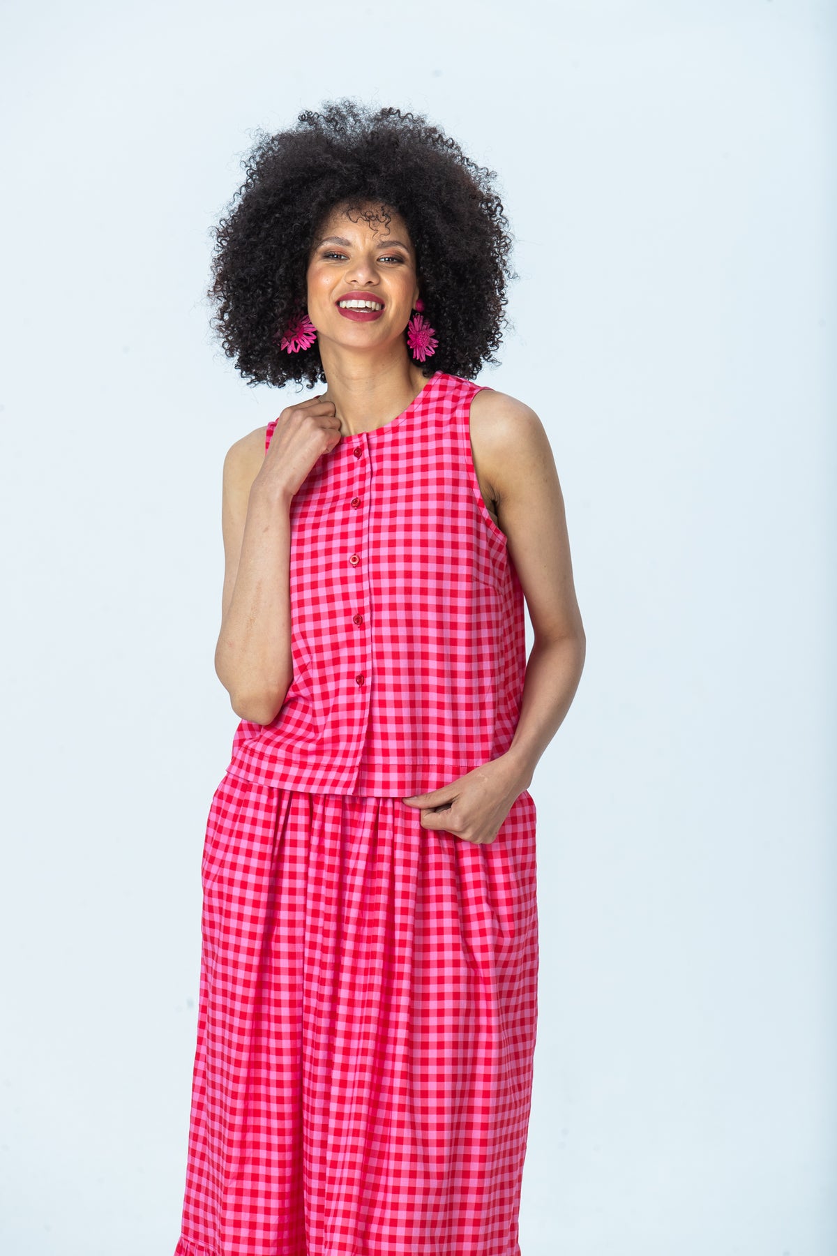 Brooke red and pink check top, front view with hand at shoulder, laughing