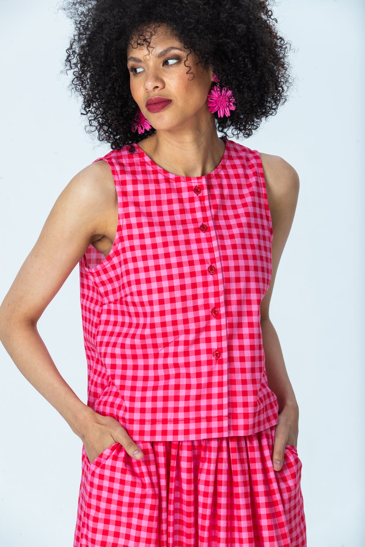 Brooke red and pink check top, three-quarter view with hands in pockets