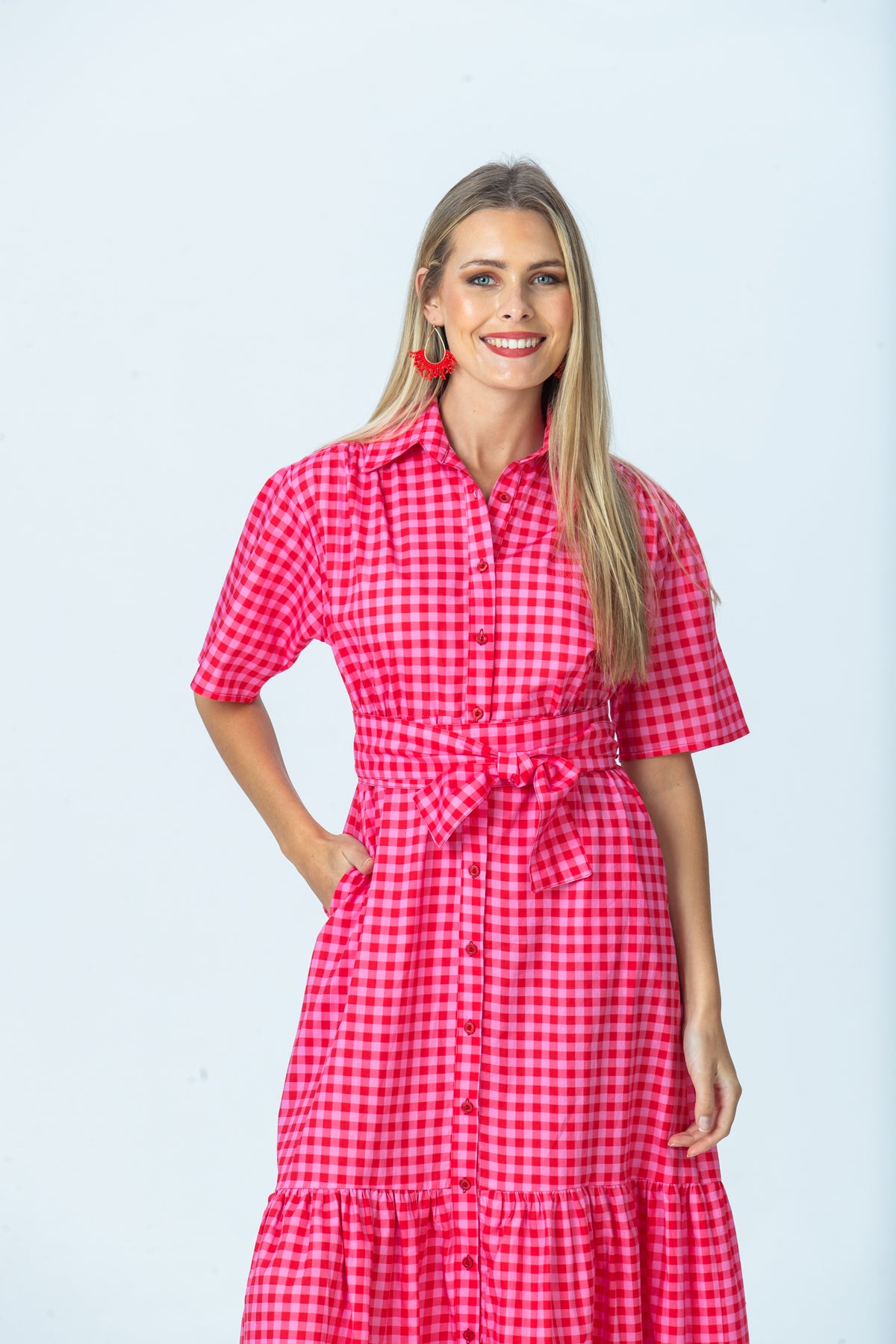 Frankie red and pink check shirt dress, front view with hand in pocket, smiling