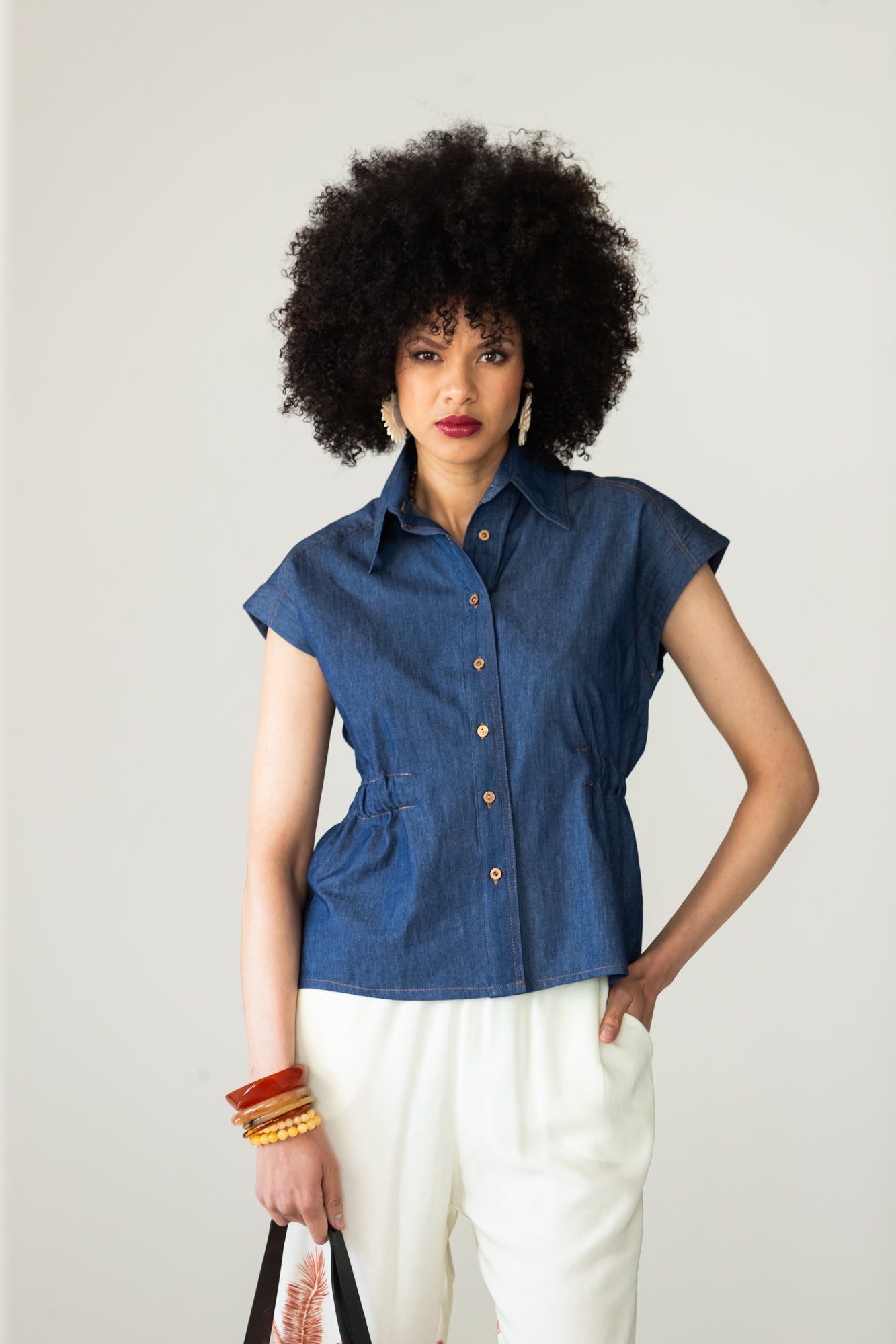 Reese denim shirt, front view with cap sleeves and belted trousers