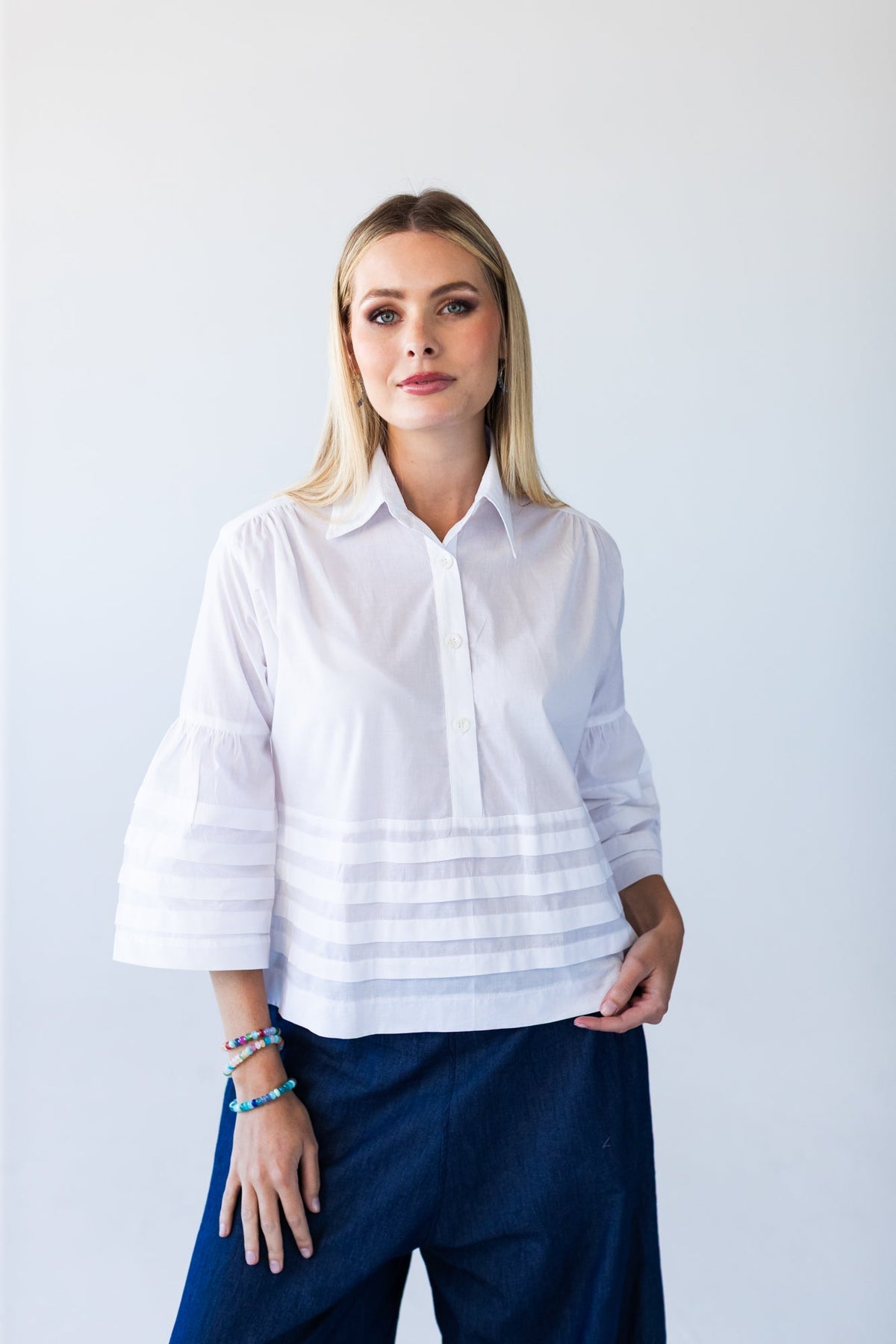Serafina white pintuck shirt, front view close up looking to the side