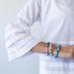 Serafina white pintuck shirt, close up of sleeve cuff with bracelets
