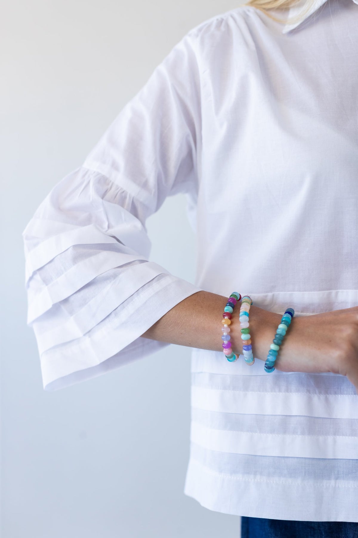 Serafina white pintuck shirt, close up of sleeve cuff with bracelets