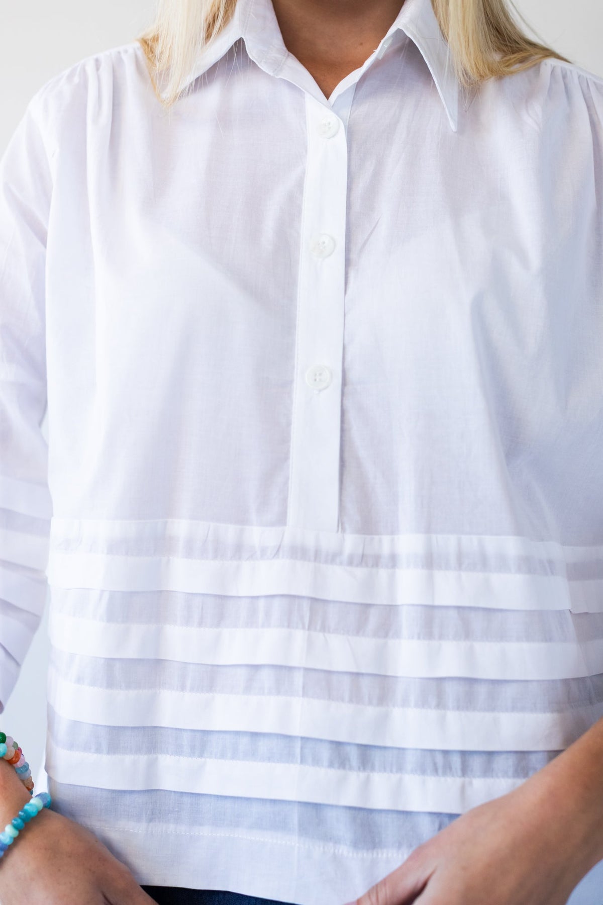 Serafina white pintuck shirt, close up of hem pintuck band and sleeve cuff detail