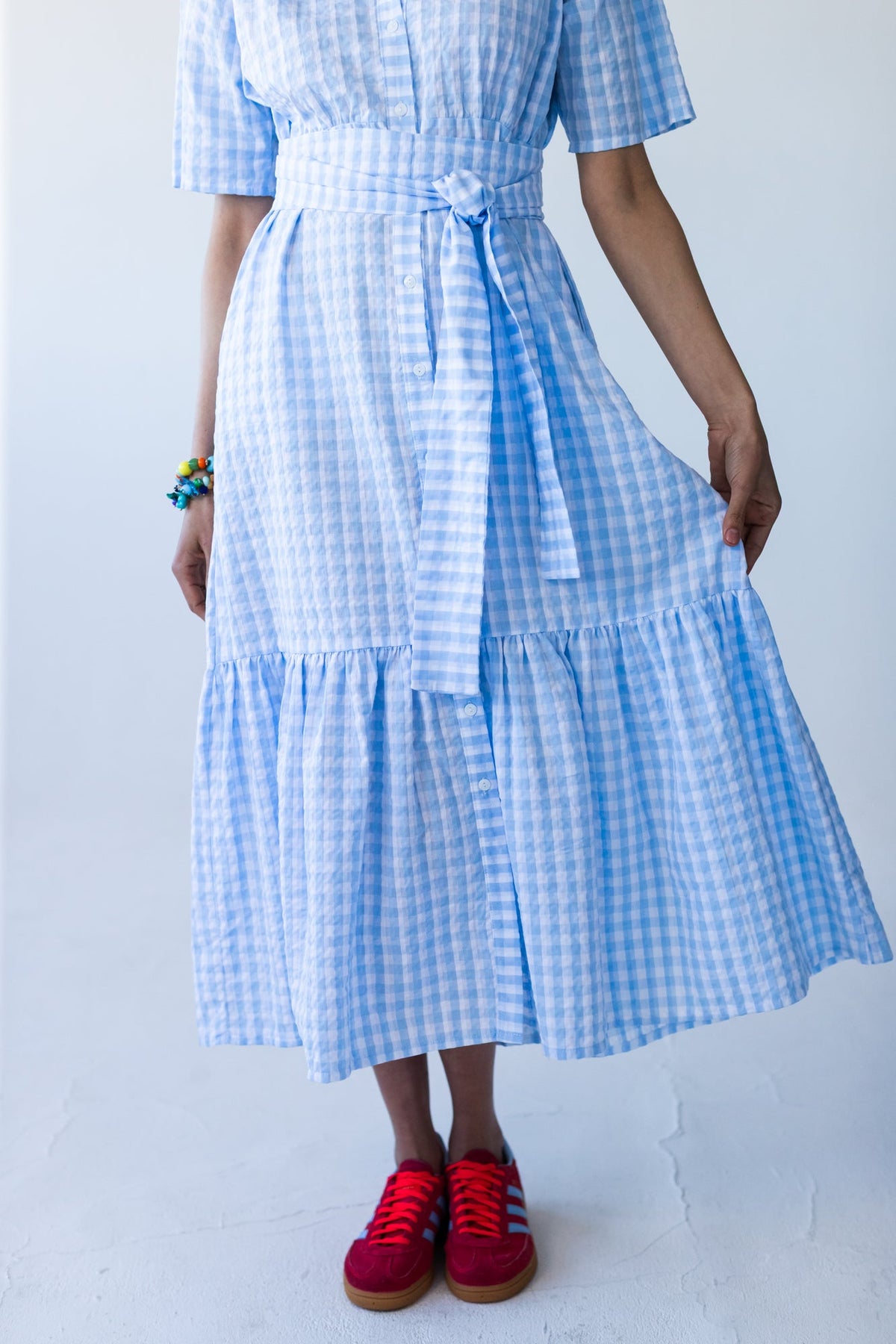Frankie blue check dress, front view holding skirt to show tiered hem