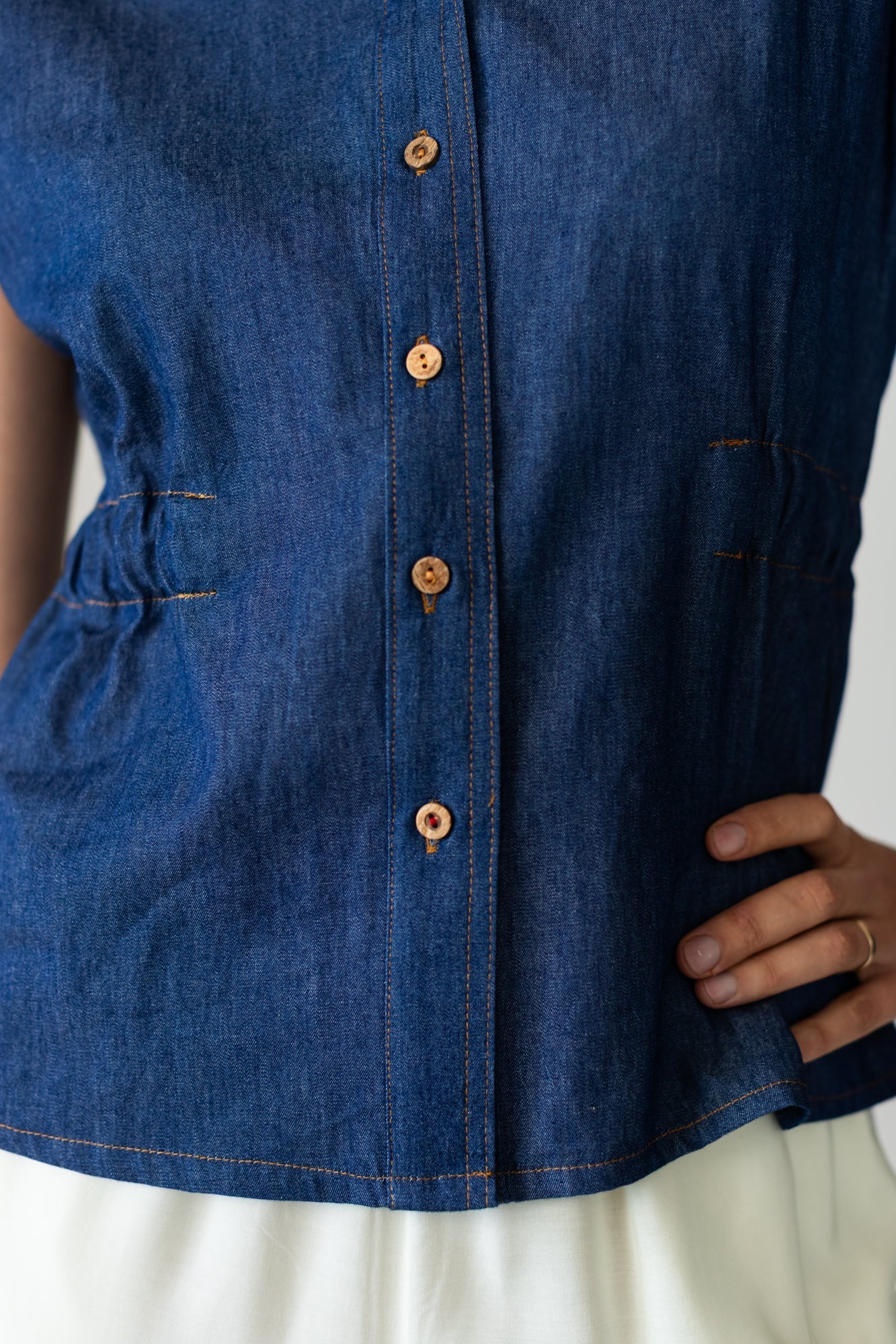 Reese denim shirt, close up of button placket and elasticated side seam