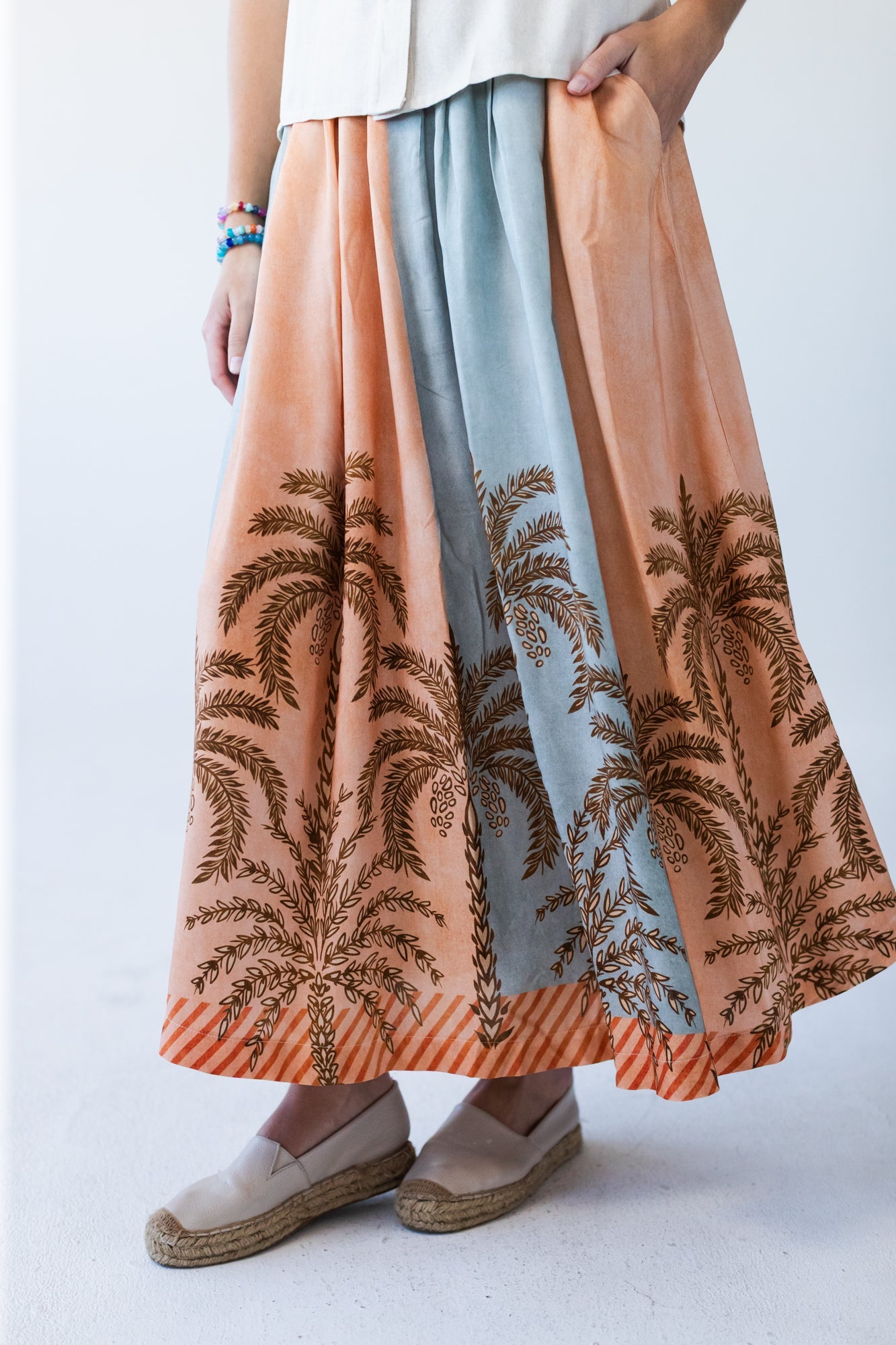 Sorrento stripe palm print skirt, close up of panels with hands at waist