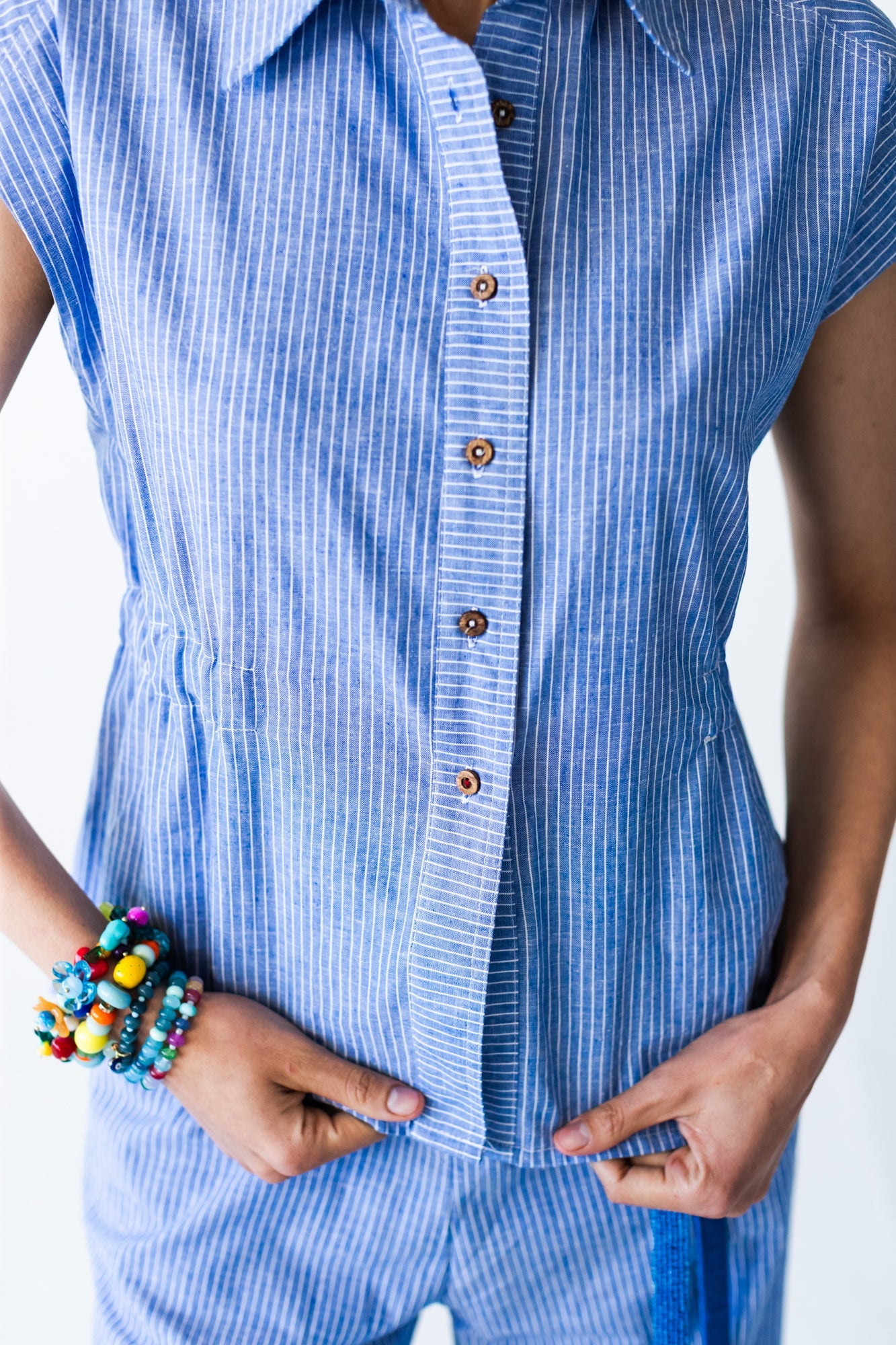 Reese stripe shirt, close up of button placket with hands at waist