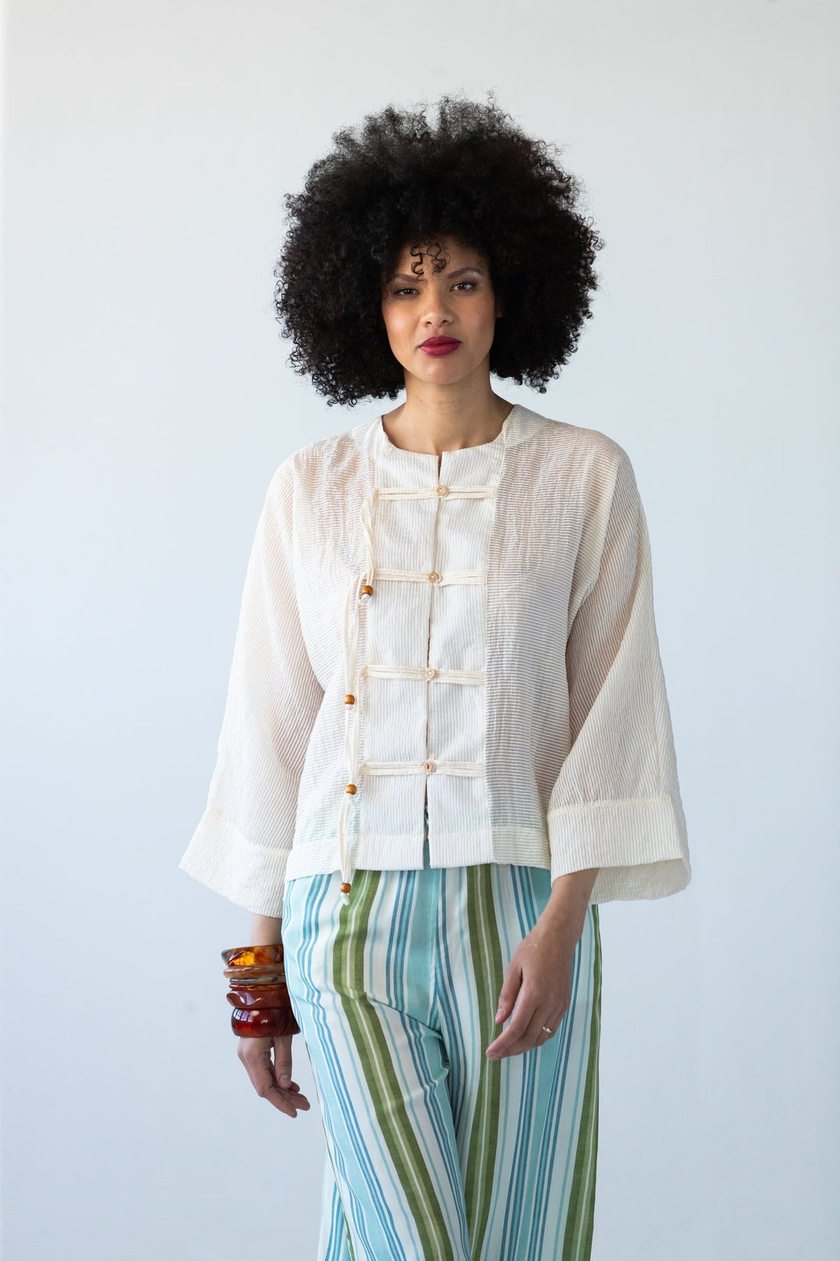 Amelia milk relaxed shirt, close up front view styled with Sydney pants in blue and green stripe