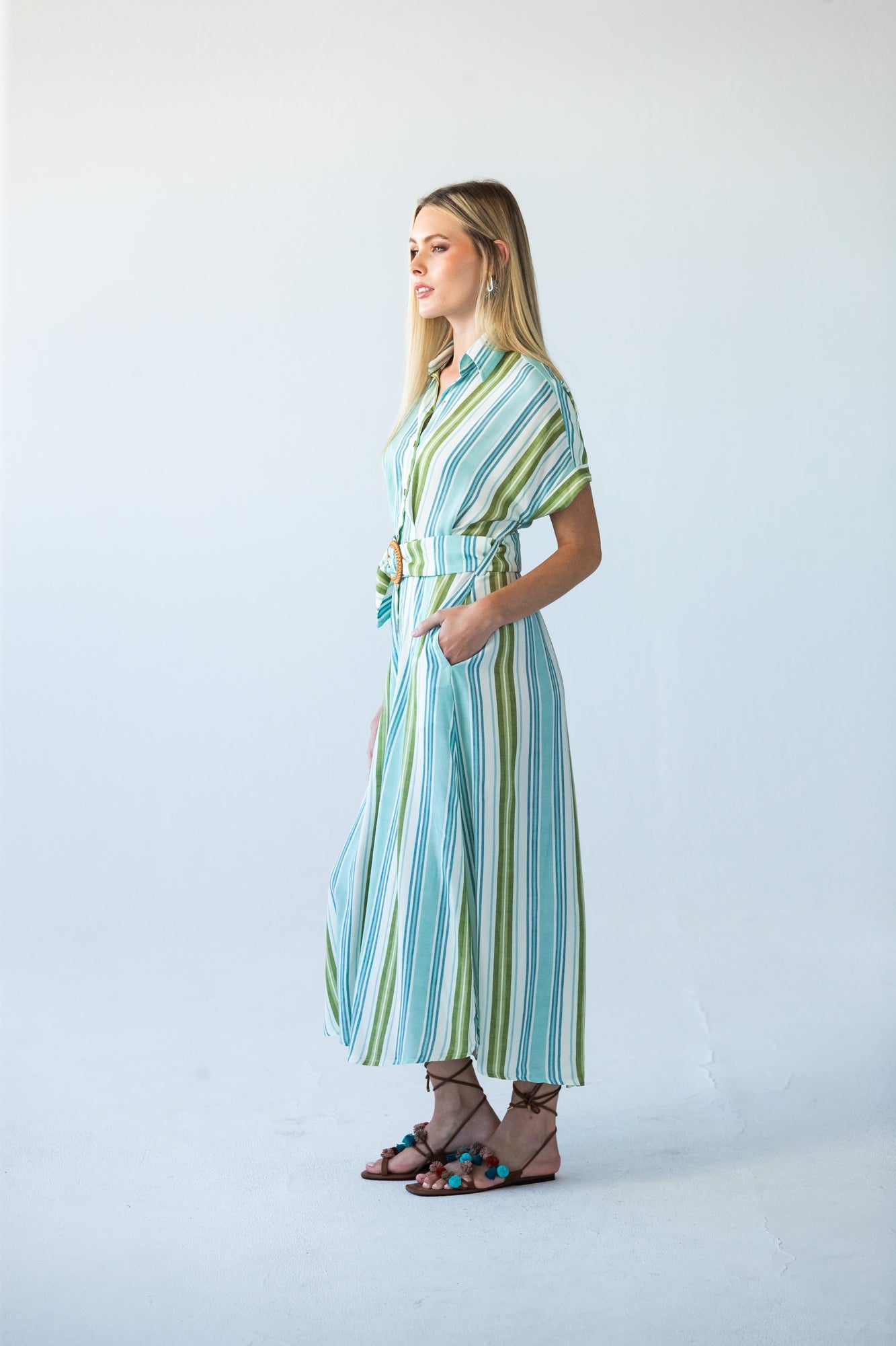 Quinn blue green stripe dress, side profile view with hand in pocket