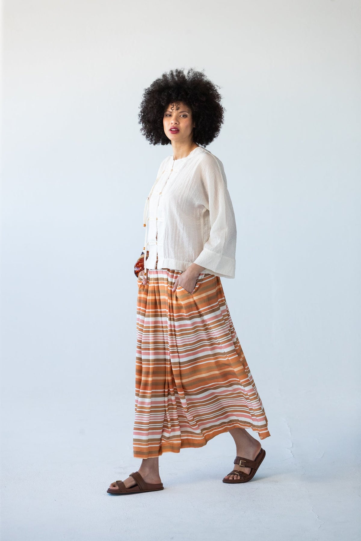 Sorrento Sunset Stripe skirt, side profile walking pose
