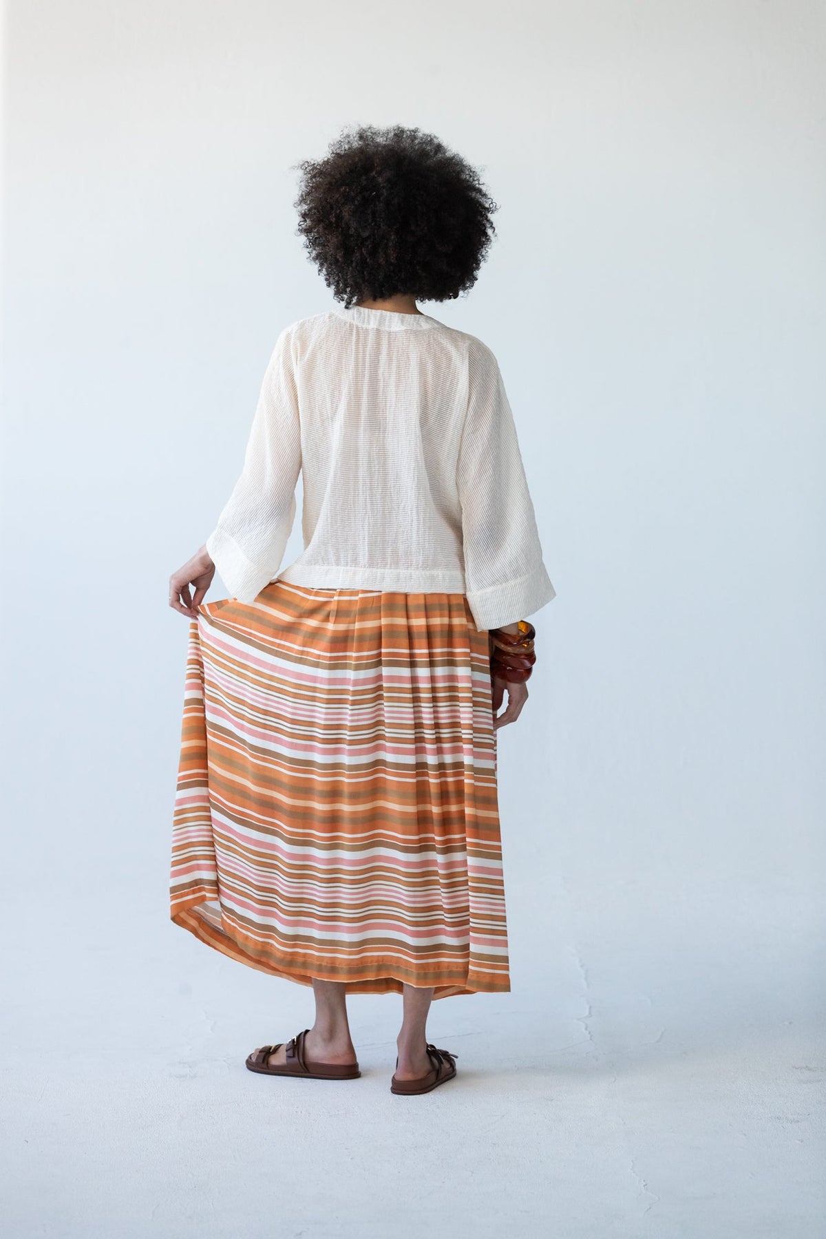 Sorrento Sunset Stripe skirt, back view holding fabric to show stripe