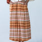 Sorrento Sunset Stripe skirt, close-up of pleated waistband, hands in pockets