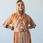 Cassidy Sunset Stripe dress, close-up front view with hands on hips, belt buckle visible