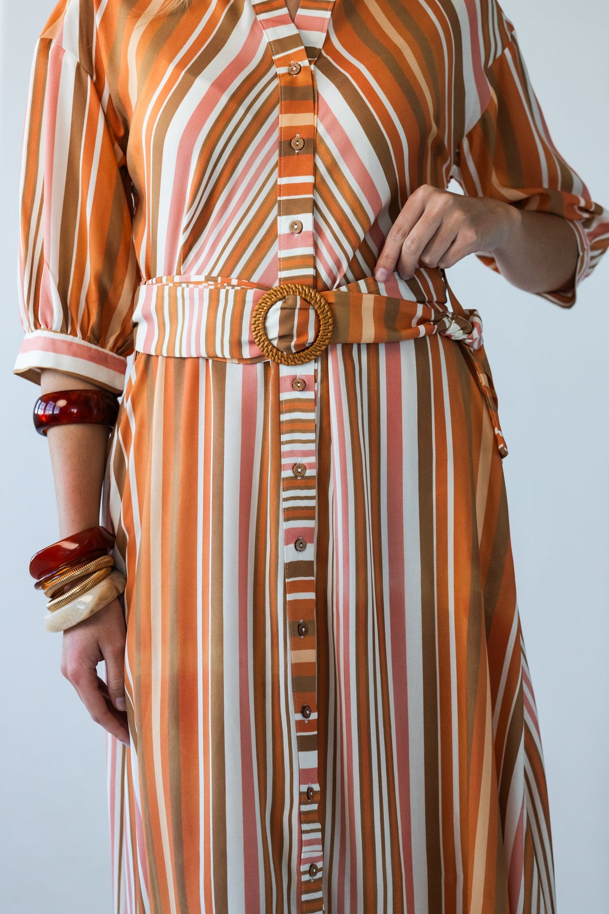 Cassidy Sunset Stripe dress, close-up of belt, woven buckle and button stand