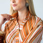 Cassidy Sunset Stripe dress, close-up of collar and neckline, model touching collar