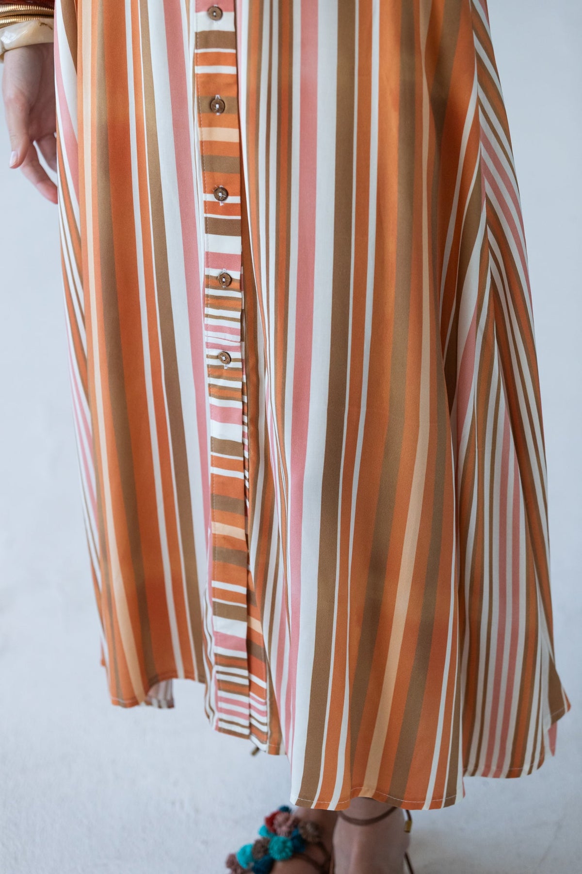 Cassidy Sunset Stripe dress, close-up of skirt showing vertical stripe and button placket