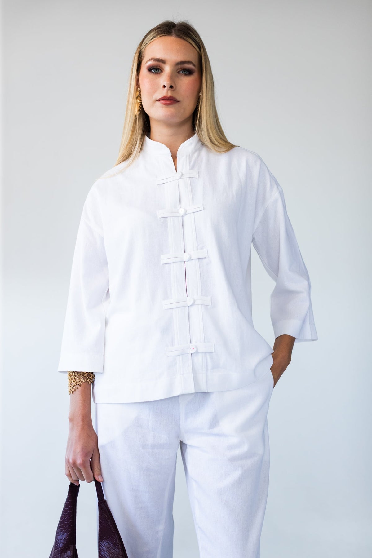 Kinsley white kaftan-style shirt, front view with hand in pocket