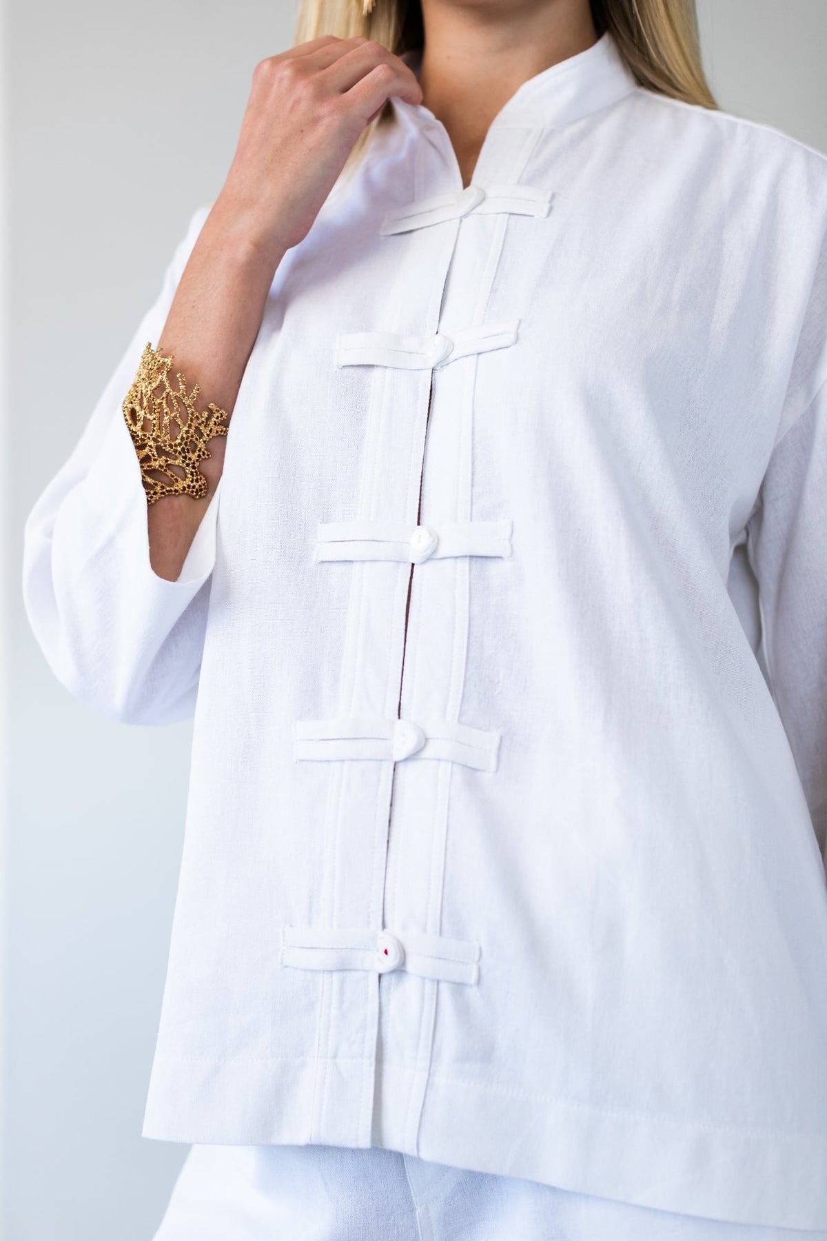 Kinsley white kaftan-style shirt, close up of collar and frog fastening