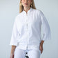 Kinsley white kaftan-style shirt, seated view with frog fastening visible