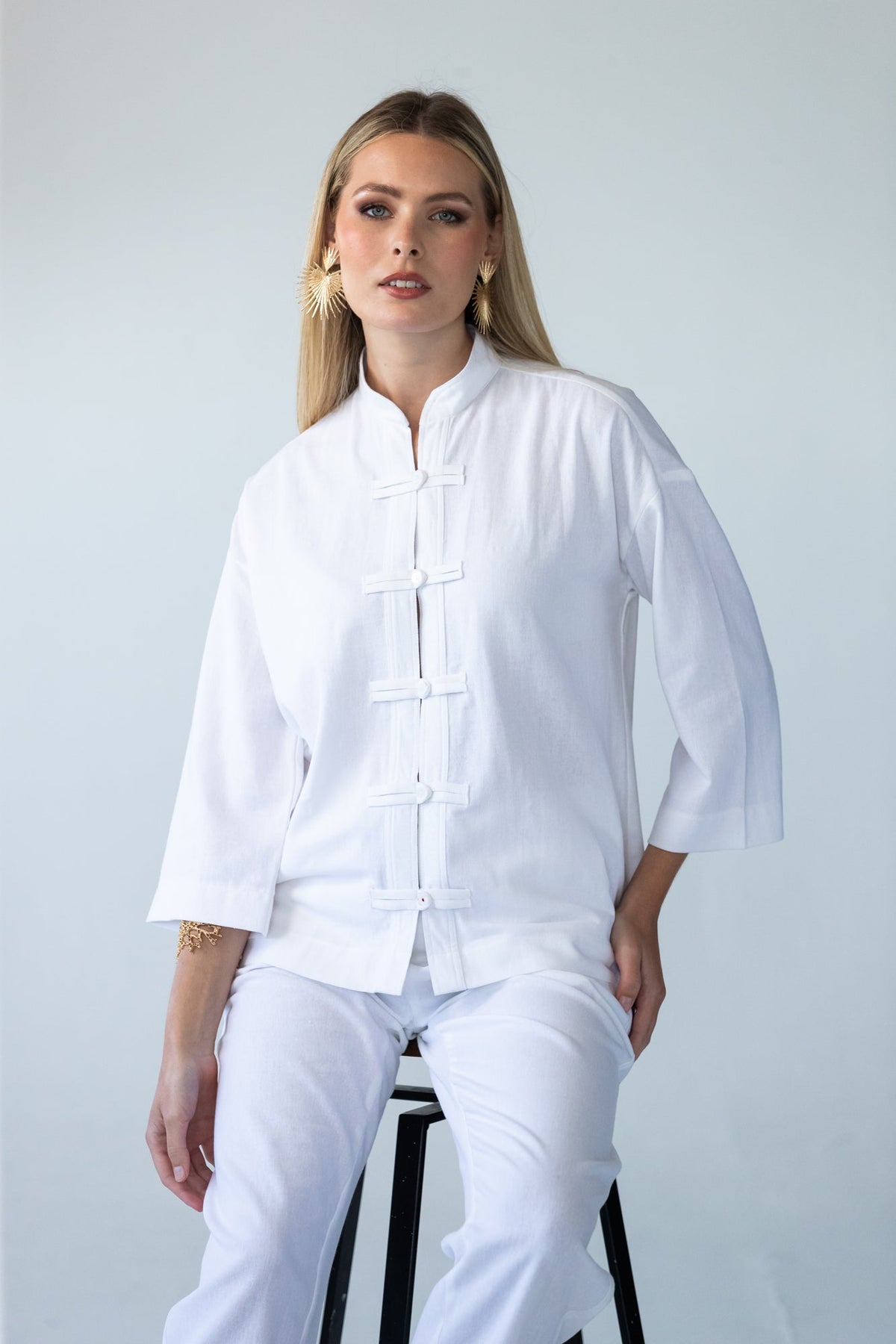 Kinsley white kaftan-style shirt, seated view with frog fastening visible