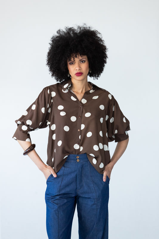 Harper 3/4 sleeve shirt in chocolate and cream polka dot, front view with hands in pockets