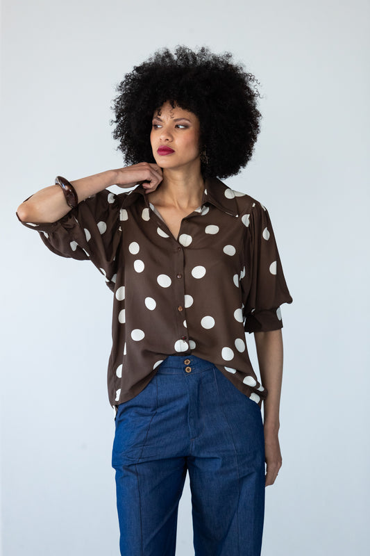 Harper polka dot shirt, front view with one hand at the collar showing the balloon sleeves