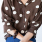 Harper polka dot shirt, front close-up with arms crossed showing cuffs and buttons