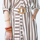 Cassidy stripe dress, close up of button stand and belt buckle and hand in pocket
