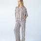 Sydney chocolate stripe wide leg pants, front view looking to the side with hand in pocket