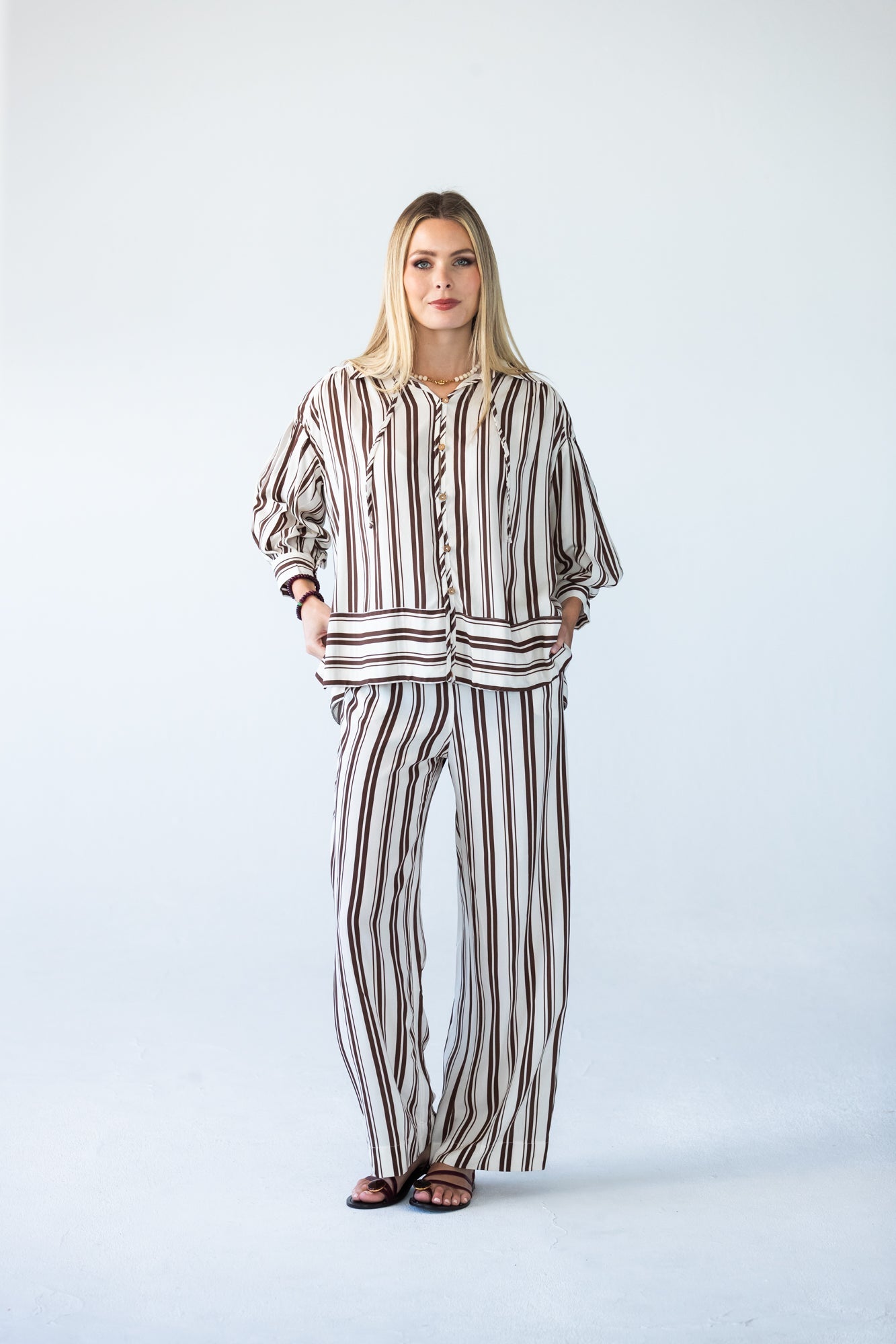 Sydney chocolate stripe wide leg pants, front view with hands on hips
